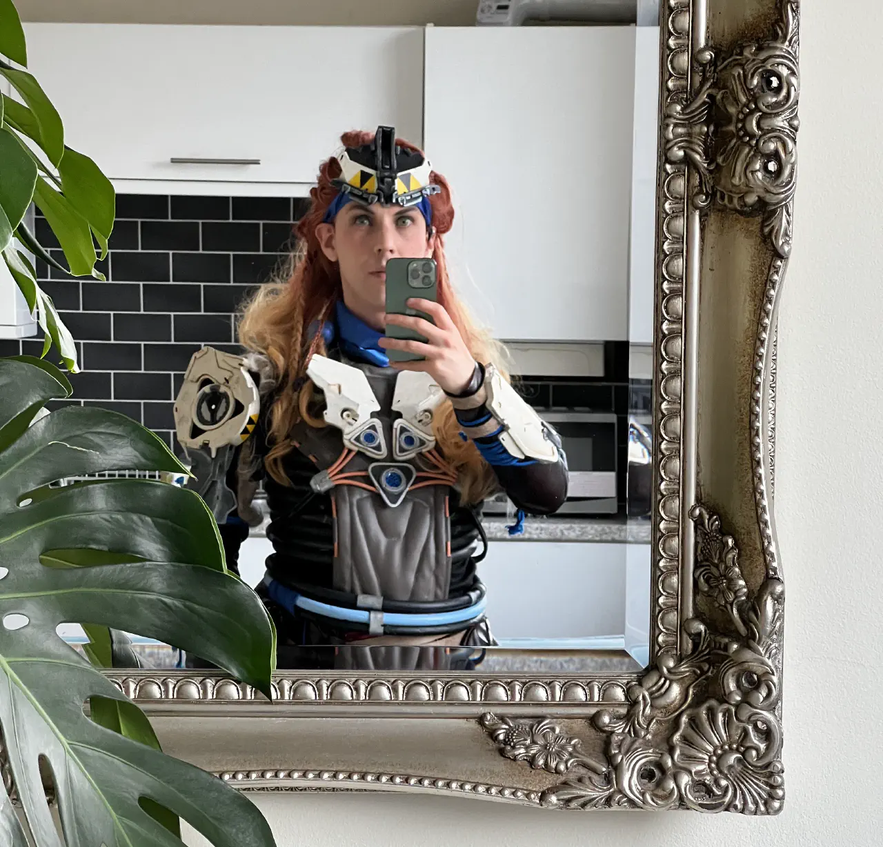 A selfie of myself dressed as Aloy in the shield weaver outfit, reflected in a fancy mirror.