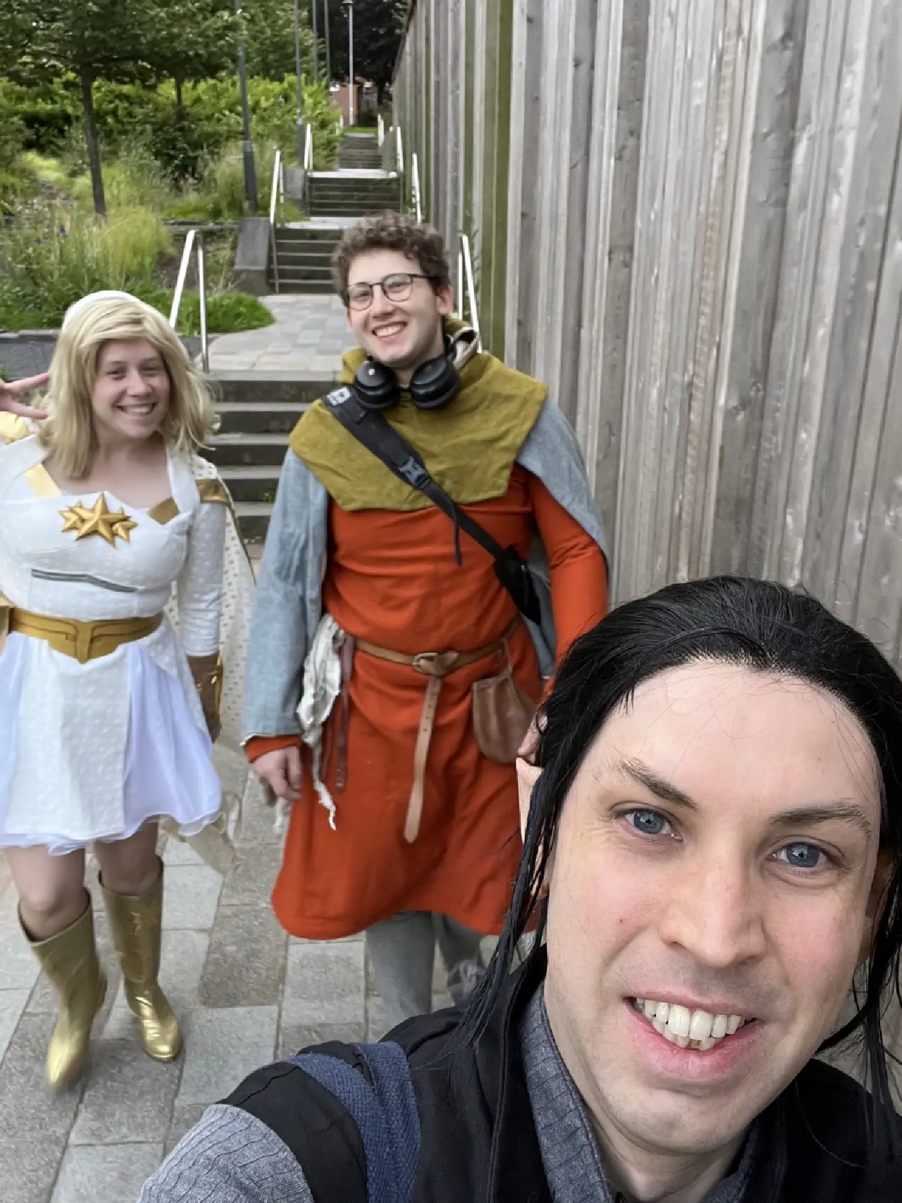 Three people in a selfie. One is dressed as Vax, though you can only see their head. On the left one is dressed as Starlight and the other in an orange norman style outfit.
