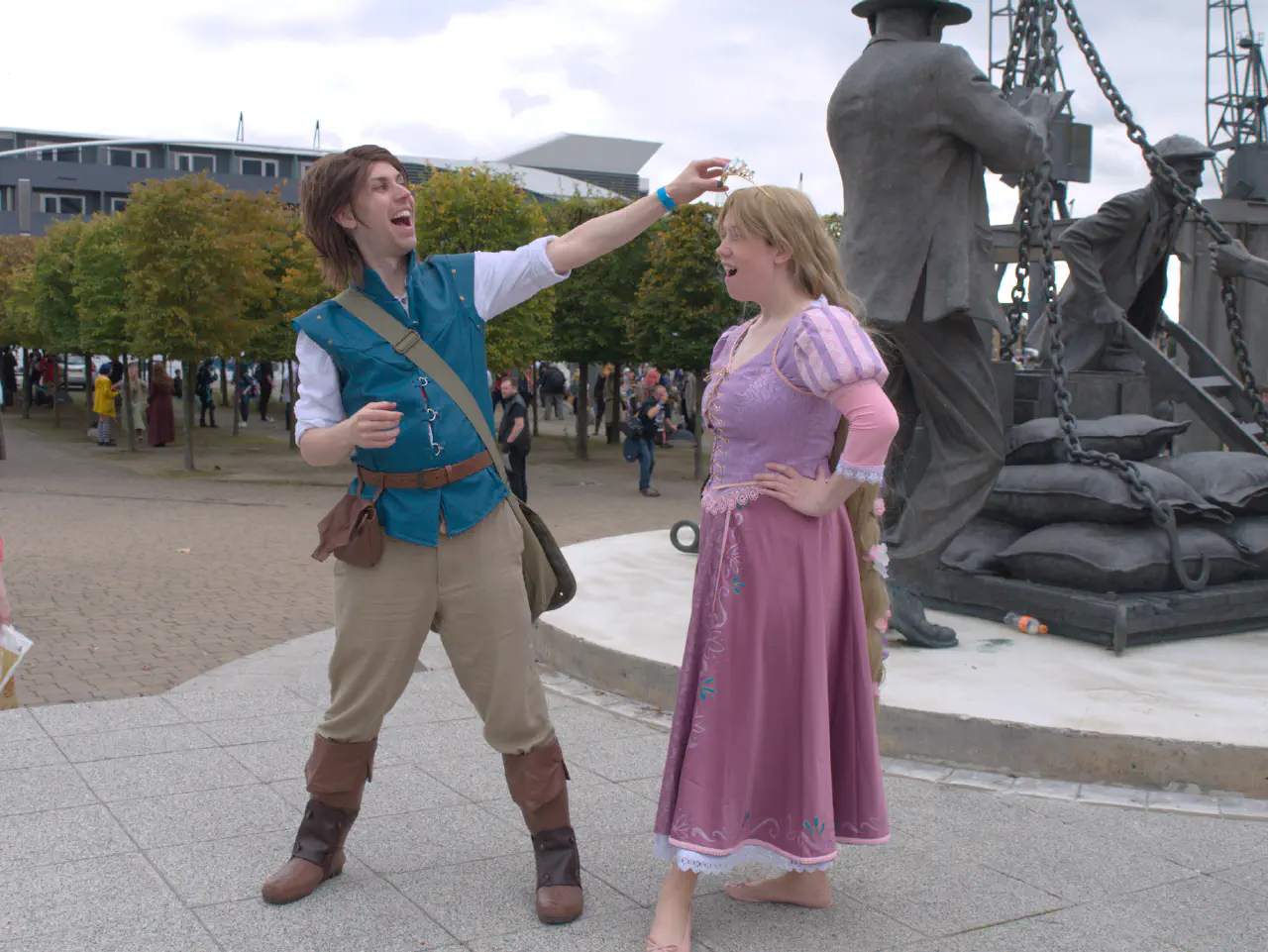 A individual in a greenish jerkin stealing a crown from an individual in a pink dress.