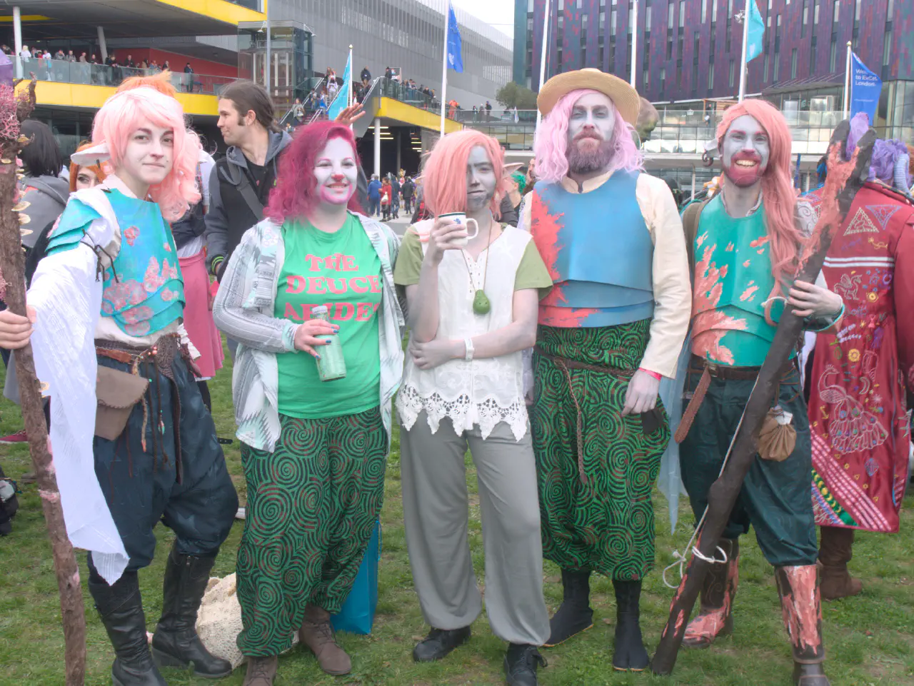 Five individuals lined up outside the Excel on a patch of grass, all dressed as various interpretations of Caduceus Clay