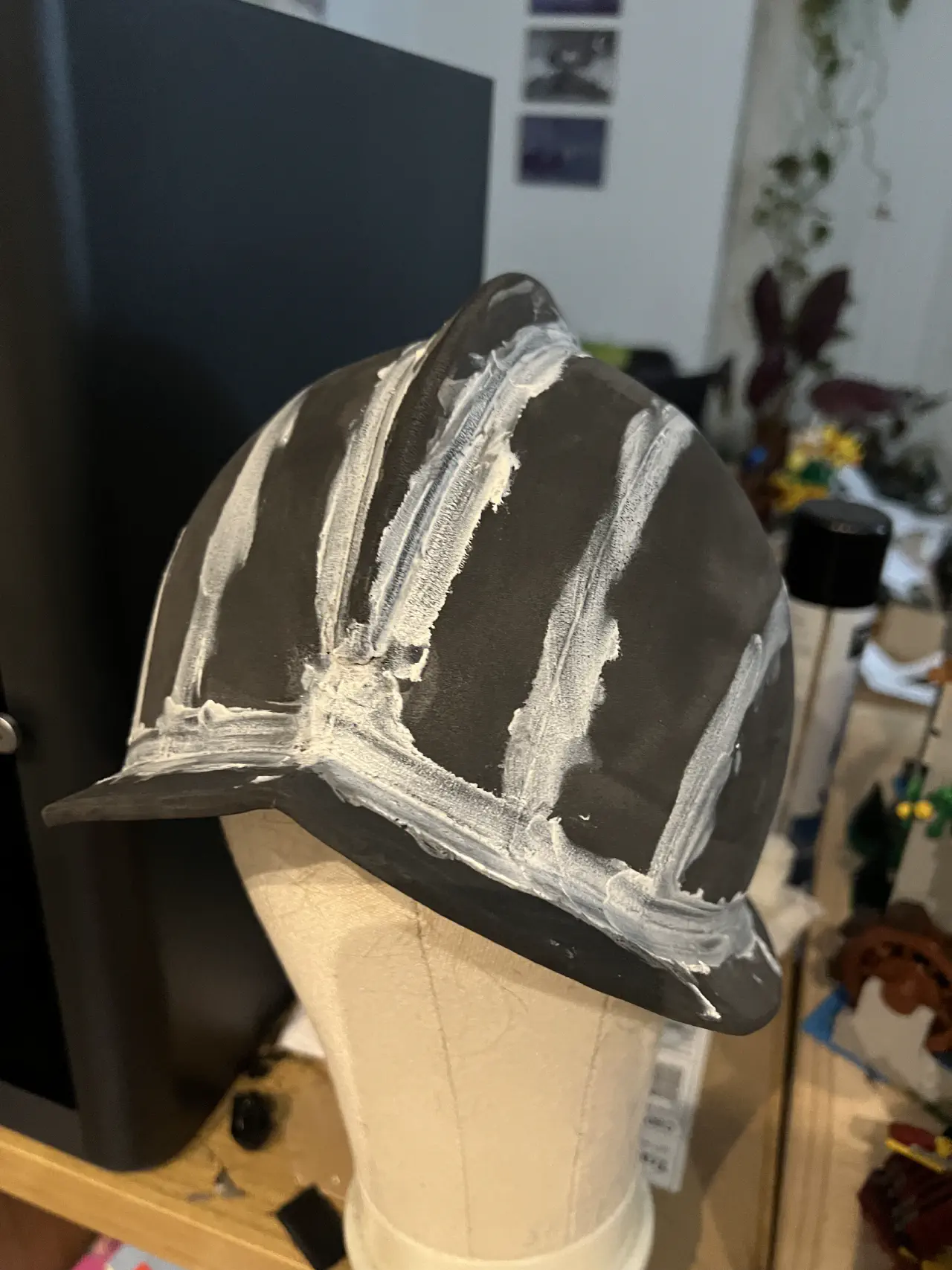 A foam helmet on a wig head, the gaps between sections covered with lines of filler